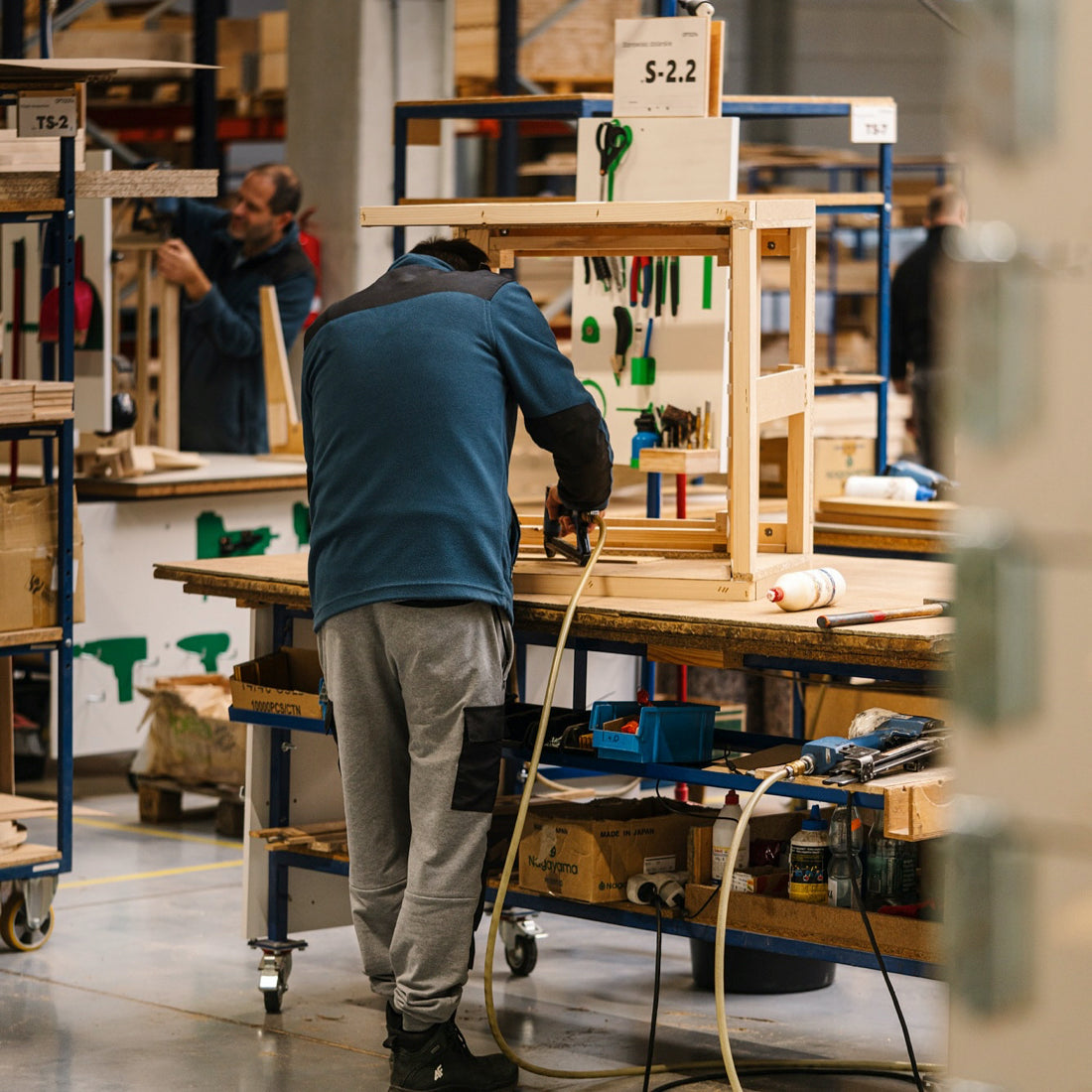 Artisan façonnant un canapé C’est Canapé avec précision et savoir-faire.