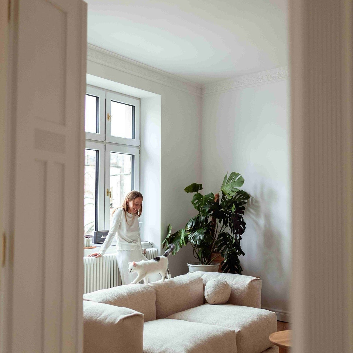 Canapé modulable Cloud en tissu écru vu depuis le couloir d’un appartement