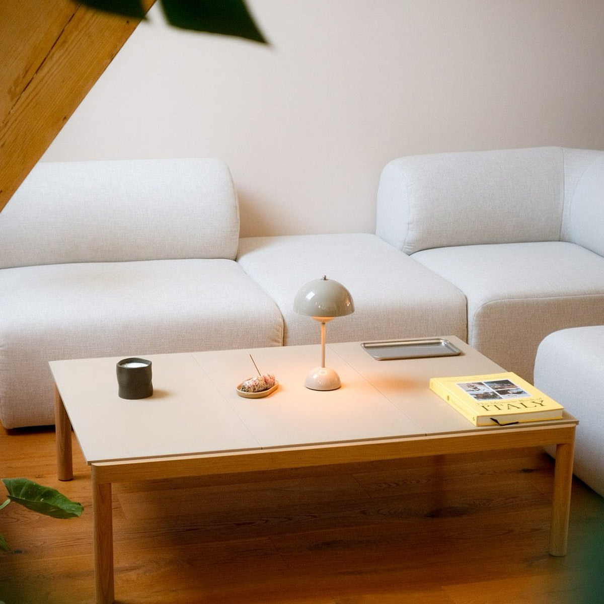 Canapé modulable Hug en tissu blanc cassé dans un salon, composition avec table basse
