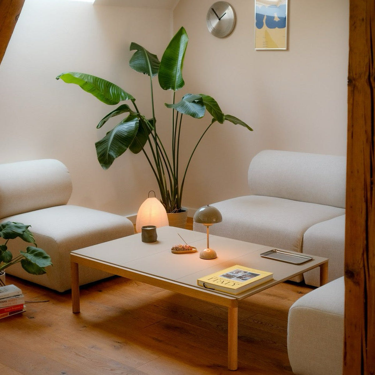 Canapé modulable Hug en tissu blanc cassé dans un salon, composition avec table basse