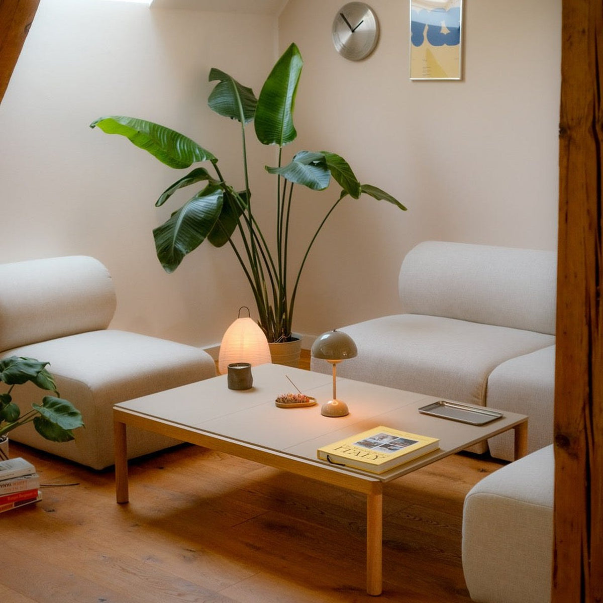Canapé modulable Hug en tissu blanc cassé dans un salon, composition avec table basse