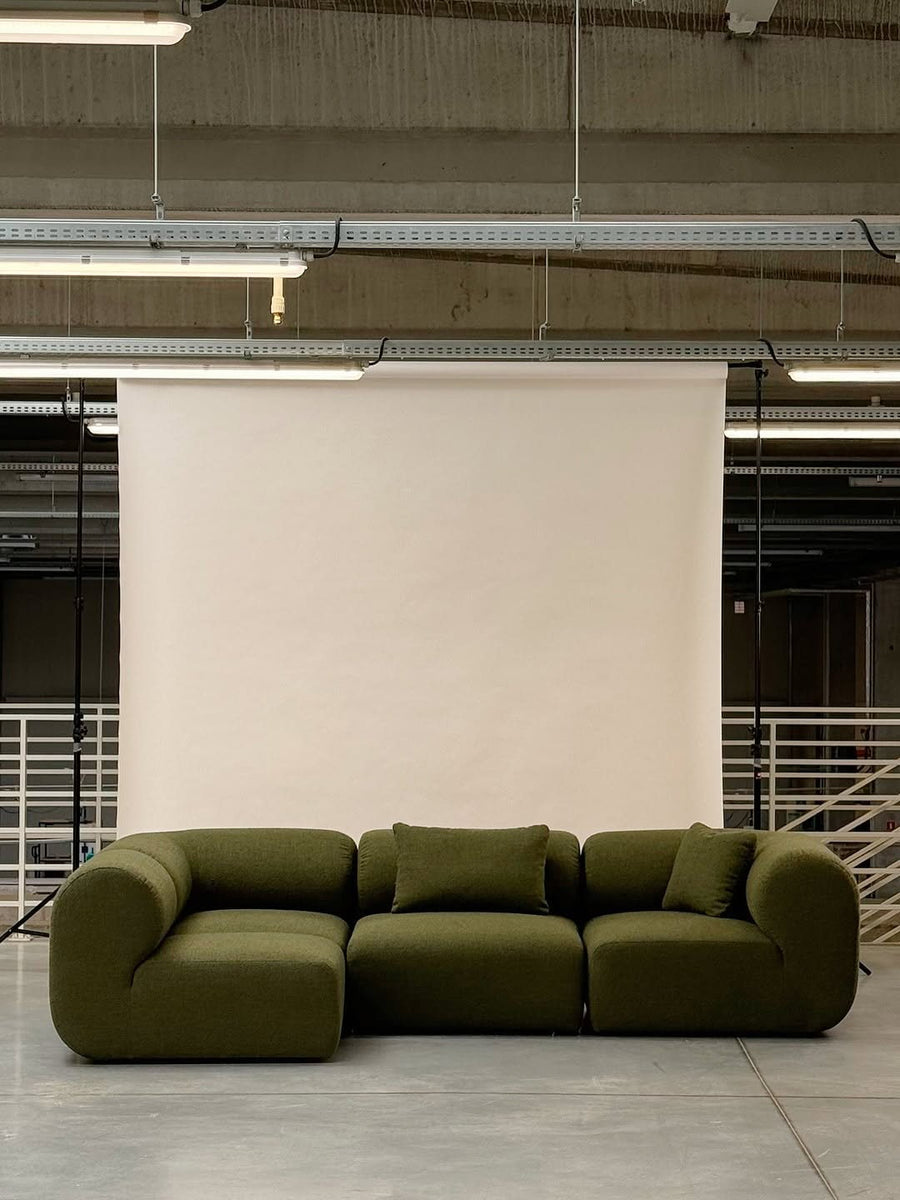 Canapé modulable Hug en tissu vert olive, trois modules aux lignes arrondies, devant une toile de fond blanche