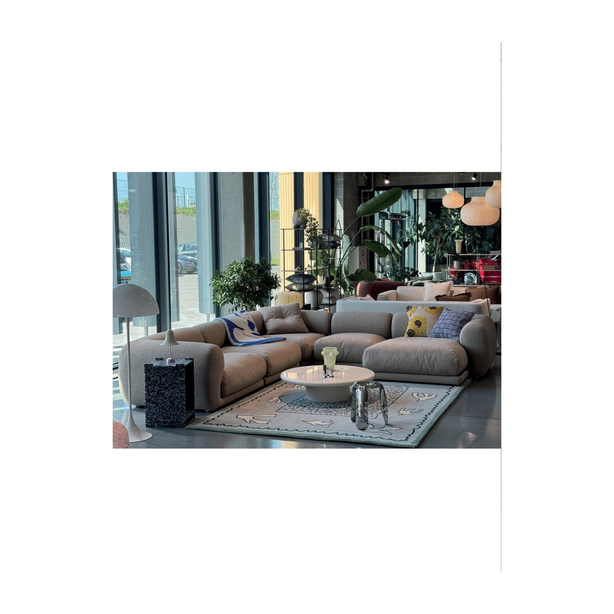 Canapé modulable Lazy en composition d'angle avec coussins, tissu beige, showroom