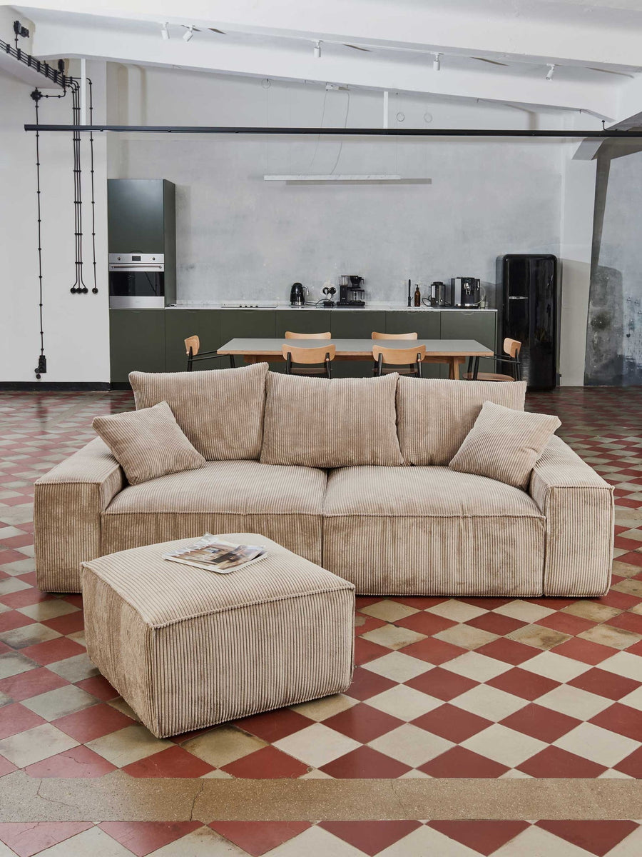 Canapé modulable Loft en velours côtelé beige trois places avec pouf, sur carreaux de ciment rouges et blancs