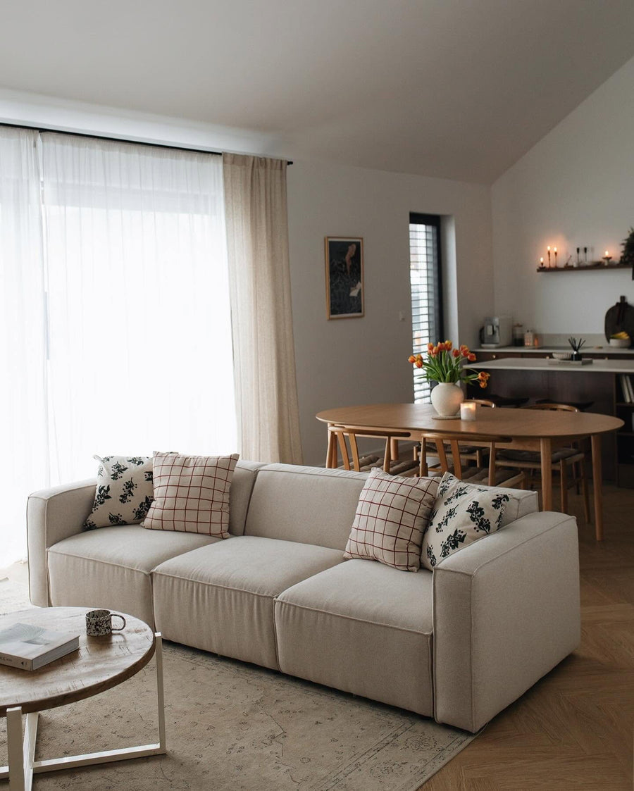 Canapé modulable Slay en tissu écru avec coussins à motifs, dans un séjour ouvert sur la salle à manger