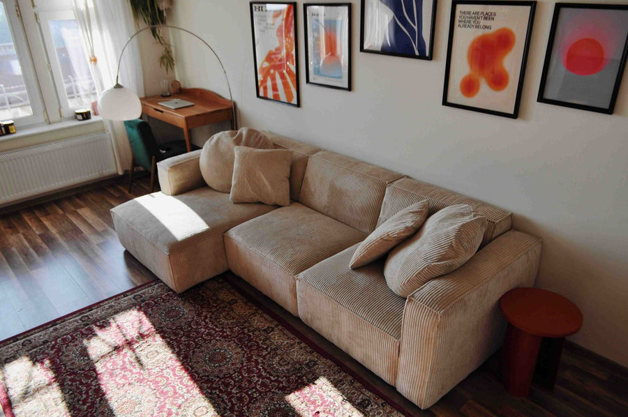 Canapé modulable Slay en velours côtelé beige avec méridienne, tapis persan et mur d’affiches colorées