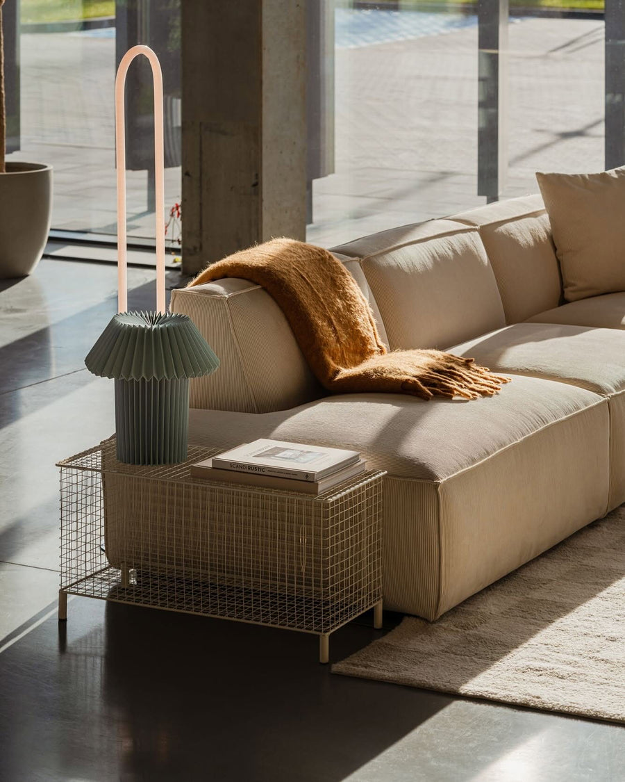 Canapé modulable Slay en velours côtelé beige avec plaid moutarde dans un loft vitré au sol en béton ciré
